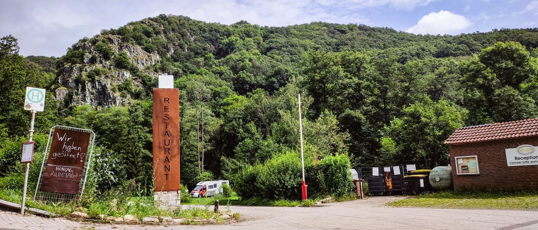 Eingang des Campingplatz, Schild Restaurant, Berge und Wohnmobil